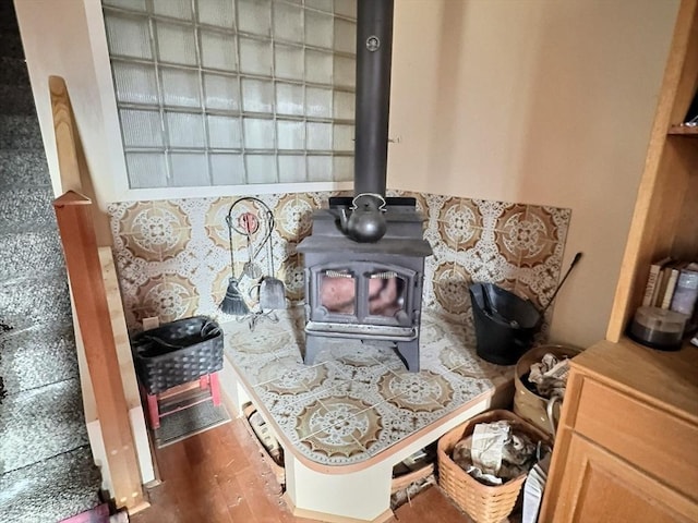 interior details with a wood stove and wood-type flooring