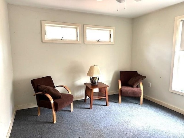 sitting room with ceiling fan and plenty of natural light