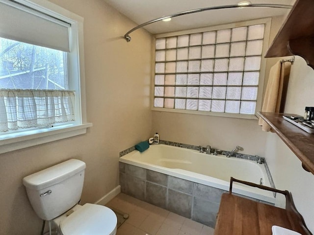 bathroom with tile patterned flooring, toilet, and tiled tub