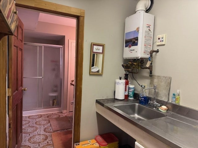 interior space with sink, a shower with shower door, and water heater