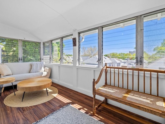 sunroom / solarium featuring wood finished floors and vaulted ceiling