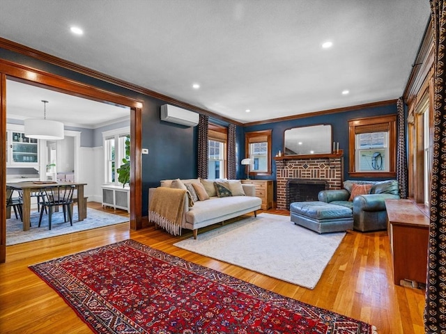 living room featuring an AC wall unit, ornamental molding, wood finished floors, a brick fireplace, and recessed lighting