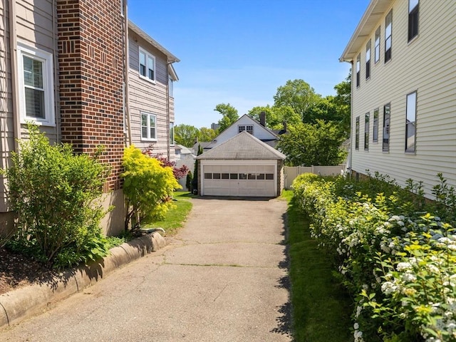 view of side of home featuring a garage and an outbuilding