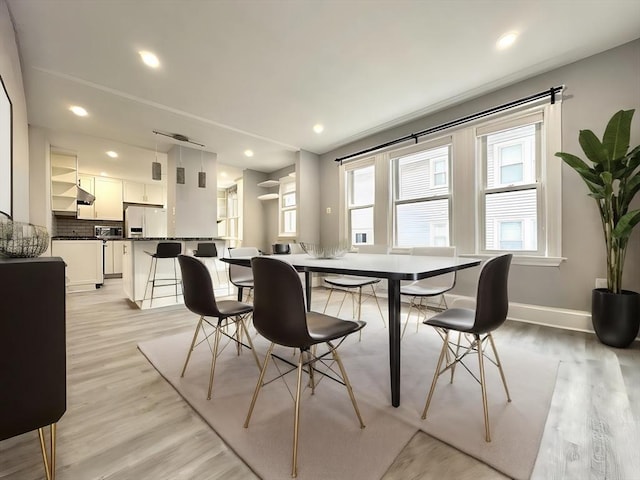 dining room featuring light wood-type flooring, baseboards, and recessed lighting