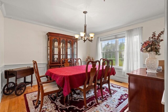 1 Cottonwood Cir, Kingston, NH 03848 - dining room with a chandelier, ornamental molding, light wood-type flooring, and wainscoting