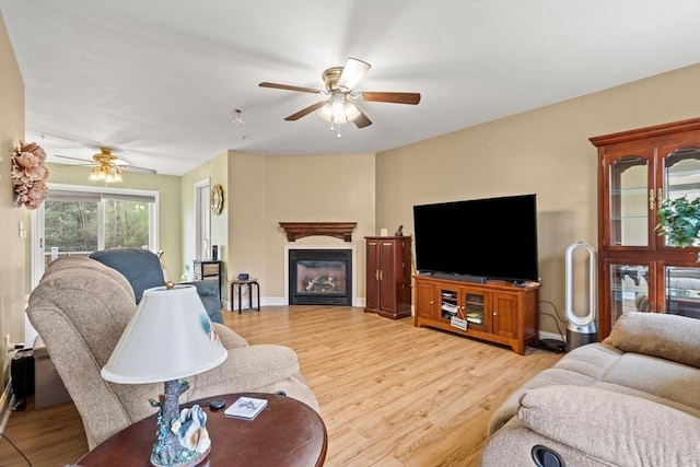 1 Cottonwood Cir, Kingston, NH 03848 - living room featuring a ceiling fan, light wood-type flooring, and a glass covered fireplace
