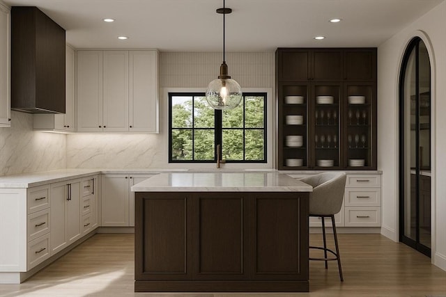 39 Rogers Ave, Somerville, MA 02144 - kitchen with light wood-style floors, white cabinetry, backsplash, recessed lighting, and a kitchen island