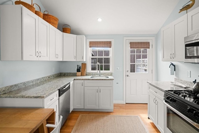 90 Broadway St Unit 90, Yarmouth, MA 02673 - kitchen with appliances with stainless steel finishes, a sink, light wood finished floors, white cabinets, and light stone countertops