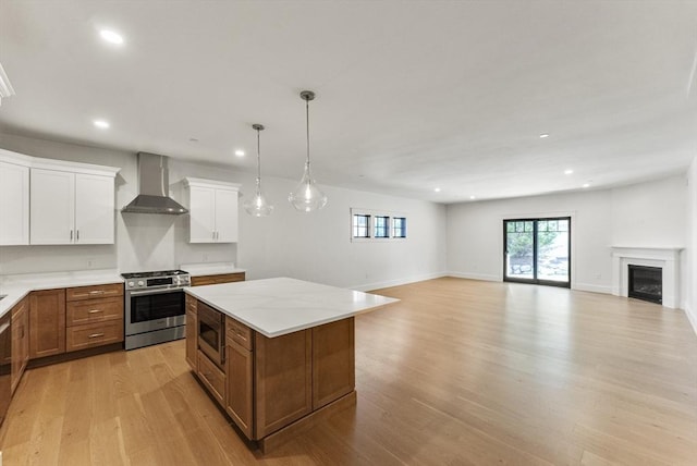 134 Court St Unit 2, Plymouth, MA 02360 - kitchen featuring open floor plan, light wood-style flooring, a kitchen island, wall chimney exhaust hood, and stainless steel appliances