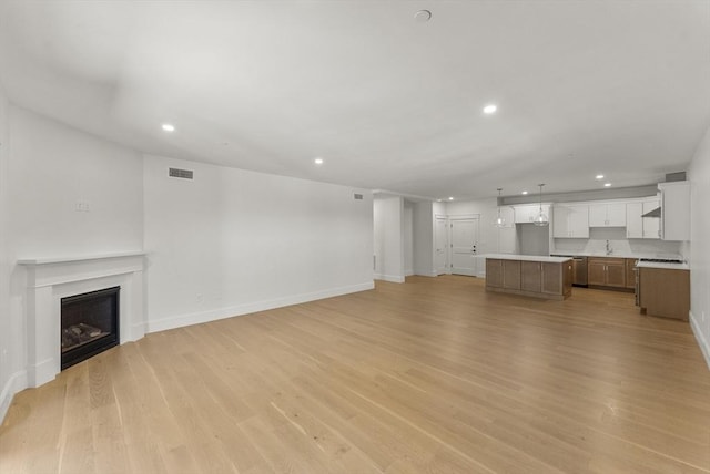 134 Court St Unit 2, Plymouth, MA 02360 - unfurnished living room with light wood-type flooring, a fireplace, visible vents, and recessed lighting