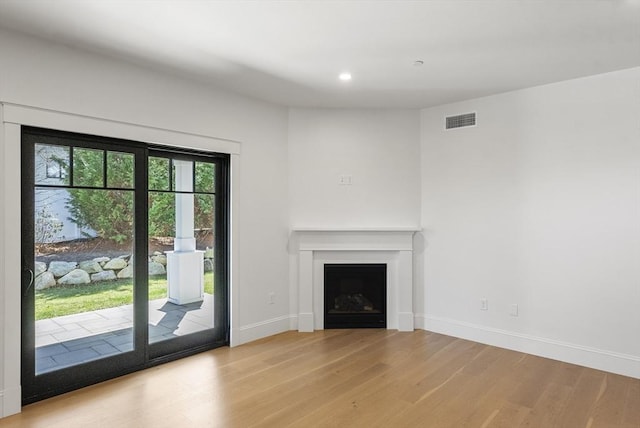 134 Court St Unit 2, Plymouth, MA 02360 - unfurnished living room featuring visible vents, baseboards, light wood finished floors, and a fireplace