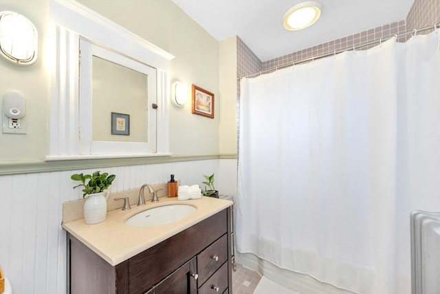 36-38 Rice St Unit 3, Cambridge, MA 02140 - bathroom featuring vanity, a wainscoted wall, and shower / bathtub combination with curtain