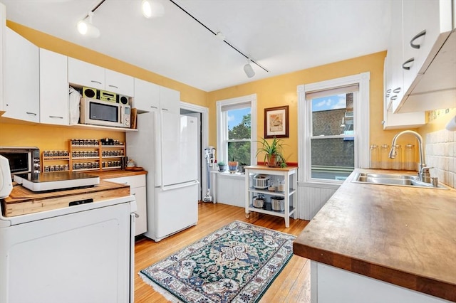 36-38 Rice St Unit 3, Cambridge, MA 02140 - kitchen featuring rail lighting, white appliances, light wood-type flooring, and washer / clothes dryer