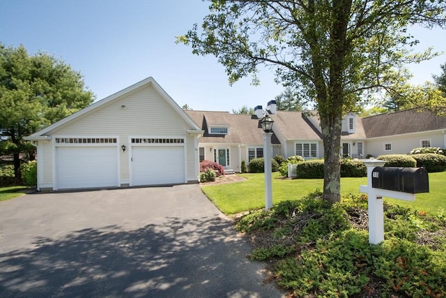 view of front of house with driveway, an attached garage, and a front lawn