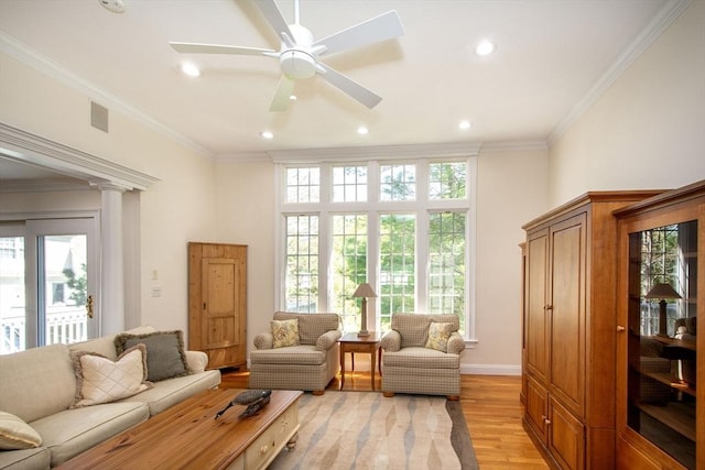 living area with ornamental molding, recessed lighting, light wood finished floors, baseboards, and ceiling fan