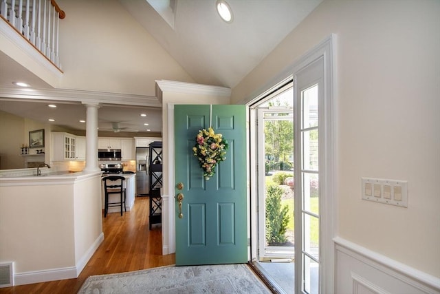 entrance foyer featuring visible vents, high vaulted ceiling, recessed lighting, light wood finished floors, and decorative columns