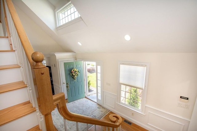 entrance foyer with stairway, a healthy amount of sunlight, visible vents, and wainscoting