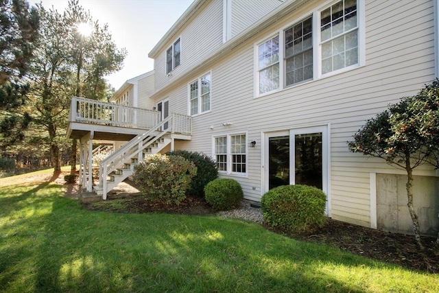 rear view of property with stairway, a lawn, and a wooden deck