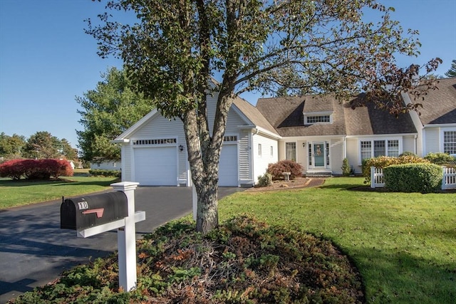 cape cod-style house featuring a front yard, a garage, and driveway