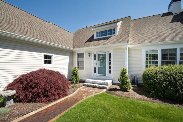 doorway to property with a shingled roof