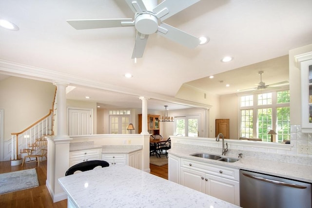 kitchen featuring ornamental molding, a sink, white cabinetry, dishwasher, and ornate columns