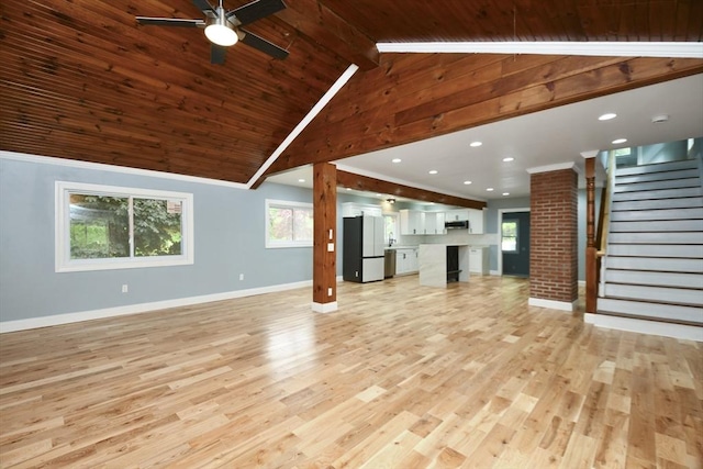 unfurnished living room featuring light wood-type flooring, a ceiling fan, stairs, and baseboards