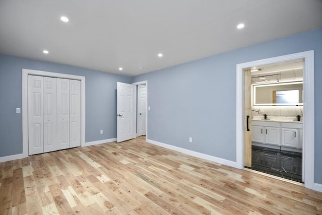 unfurnished bedroom featuring recessed lighting, ensuite bath, light wood-style flooring, and baseboards