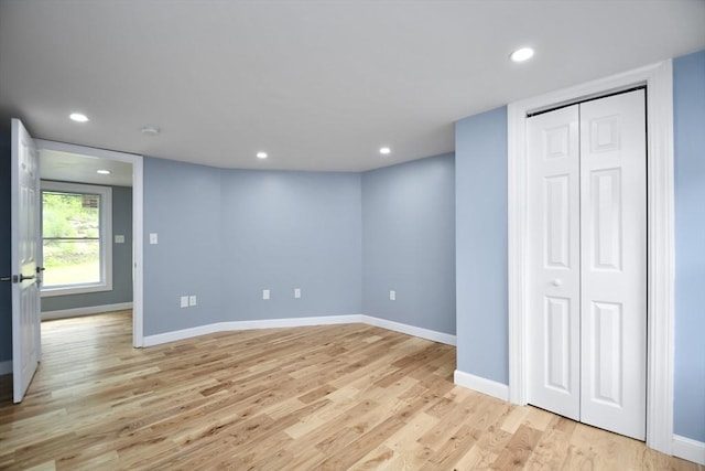 basement with baseboards, light wood-type flooring, and recessed lighting