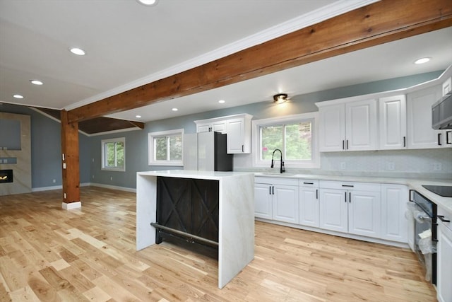 kitchen with recessed lighting, a sink, light countertops, and freestanding refrigerator