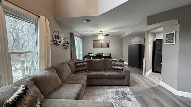 living room with ceiling fan, plenty of natural light, and light wood-type flooring