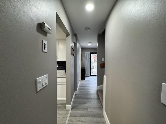 hallway with light hardwood / wood-style floors