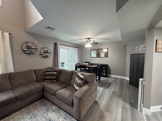 living room featuring wood-type flooring and ceiling fan