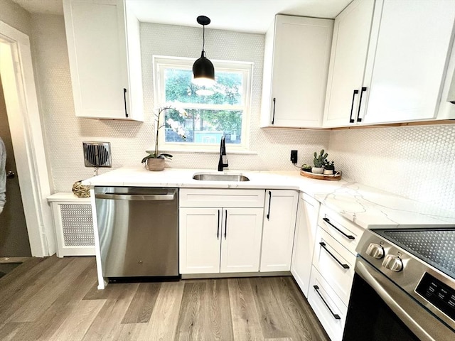 3 Rosewood Dr, Worcester, MA 01602 - kitchen featuring stainless steel appliances, light wood-style flooring, decorative backsplash, and white cabinets