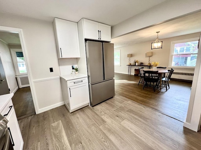 3 Rosewood Dr, Worcester, MA 01602 - kitchen with freestanding refrigerator, light wood finished floors, radiator heating unit, and white cabinetry