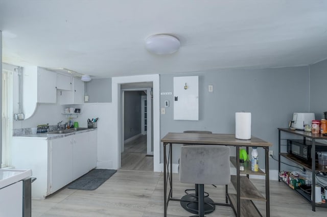 14 Sutton Ave, Oxford, MA 01540 - kitchen with white cabinets, a sink, light countertops, and black microwave