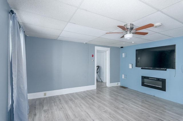 14 Sutton Ave, Oxford, MA 01540 - unfurnished living room featuring a drop ceiling, wood finished floors, ceiling fan, and baseboards