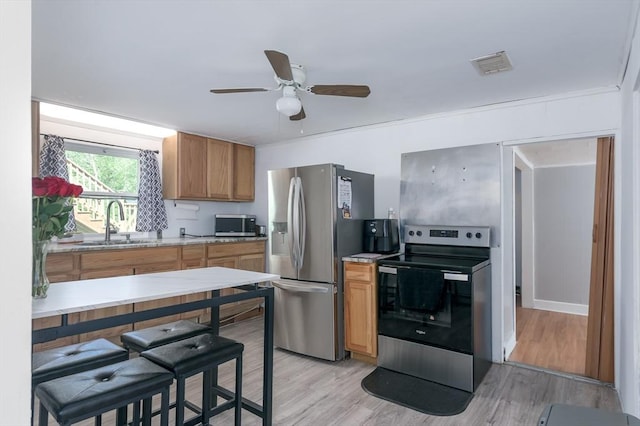 14 Sutton Ave, Oxford, MA 01540 - kitchen featuring stainless steel appliances, a sink, light wood-style floors, light countertops, and ceiling fan