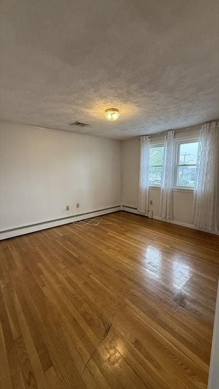 unfurnished room with wood-type flooring and baseboards