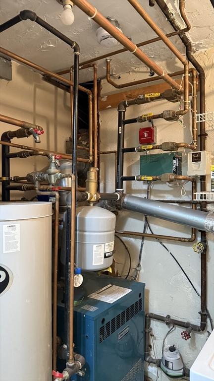 utility room with water heater and a heating unit
