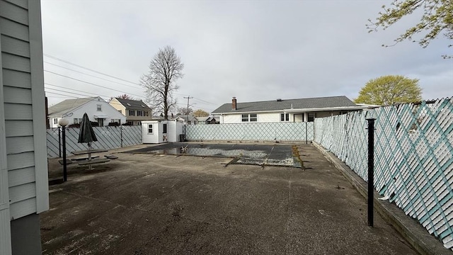 view of patio featuring a shed, a fenced backyard, and an outbuilding