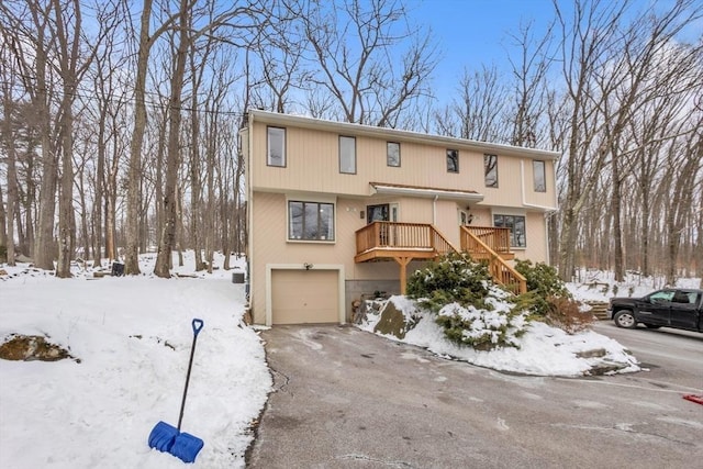 townhome / multi-family property featuring stairs, aphalt driveway, and a garage