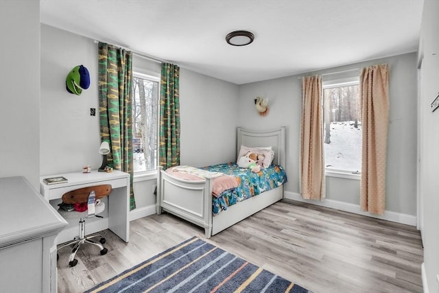 bedroom featuring baseboards and light wood finished floors