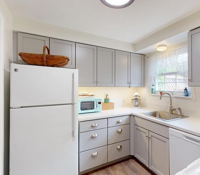 252 W St Unit 18, Amherst, MA 01002 - kitchen featuring white appliances, a sink, gray cabinets, and light countertops