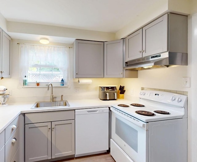 252 W St Unit 18, Amherst, MA 01002 - kitchen featuring white appliances, a sink, under cabinet range hood, gray cabinets, and light countertops