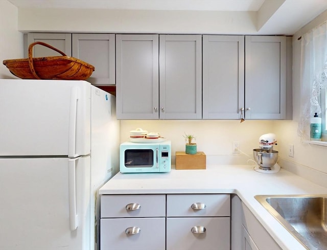 252 W St Unit 18, Amherst, MA 01002 - kitchen featuring white appliances, gray cabinets, and light countertops