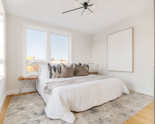 bedroom with light hardwood / wood-style floors and ceiling fan