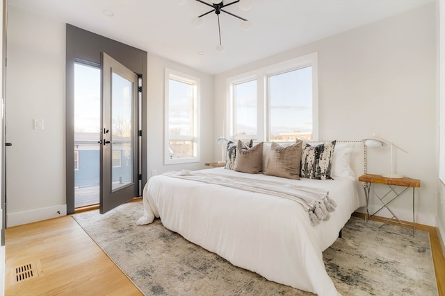 bedroom with hardwood / wood-style floors and access to outside