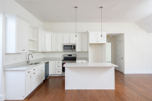 kitchen with white cabinets, stainless steel appliances, decorative light fixtures, and sink