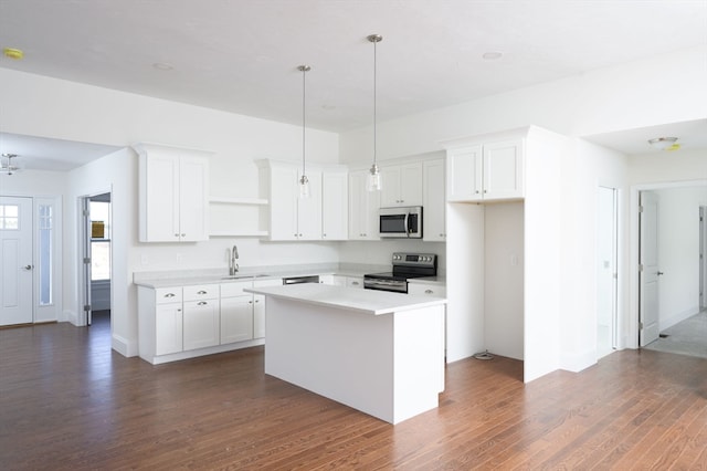 kitchen with dark hardwood / wood-style floors, stainless steel appliances, white cabinets, and a center island