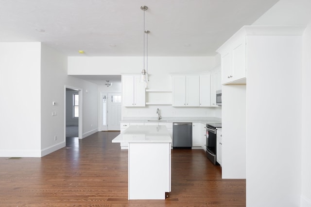 kitchen with white cabinets, stainless steel appliances, a center island, and dark hardwood / wood-style floors